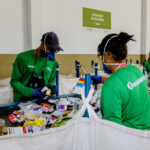 esteira de reciclagem cooperativa Recicla Guaxupé com dois colaboradores selecionando materiais recicláveis.